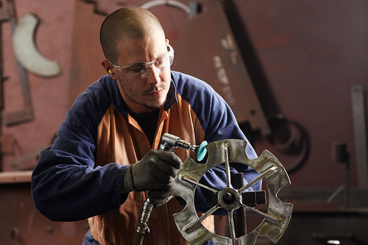 a fabricator polishing a floveyor aero-mechanical conveyor sprocket