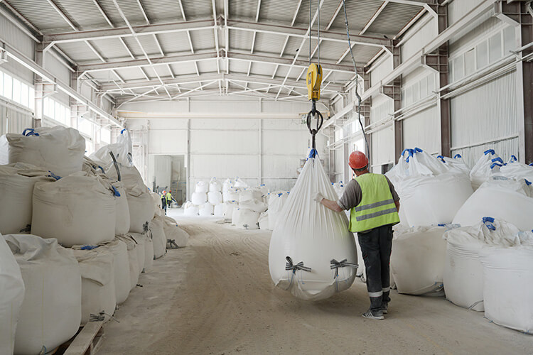 Worker in factory moving bulk bags